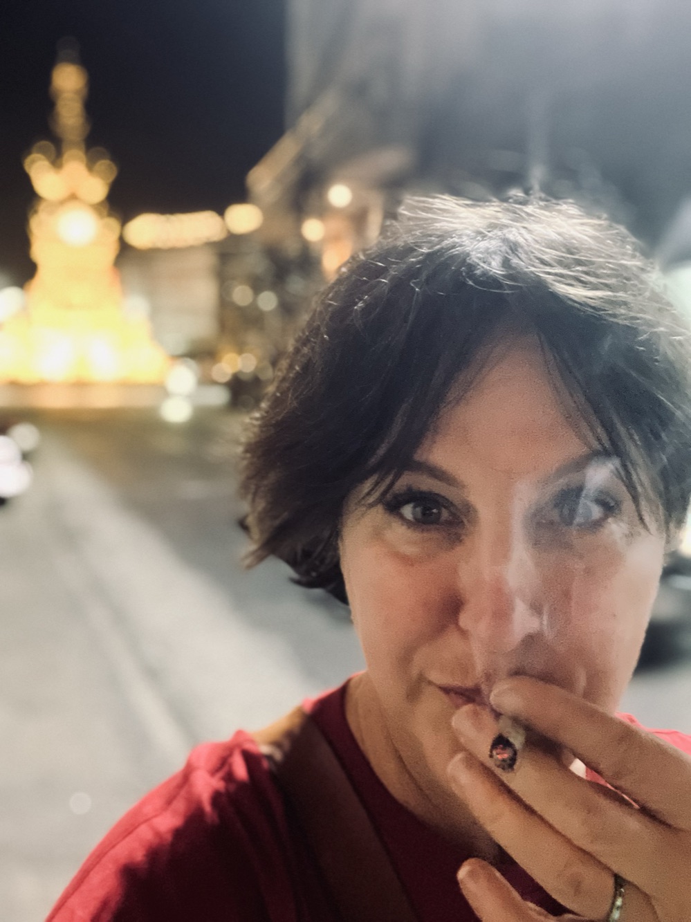 NaN at the Chiang Rai clocktower at night, its gold lights glowing behind her.